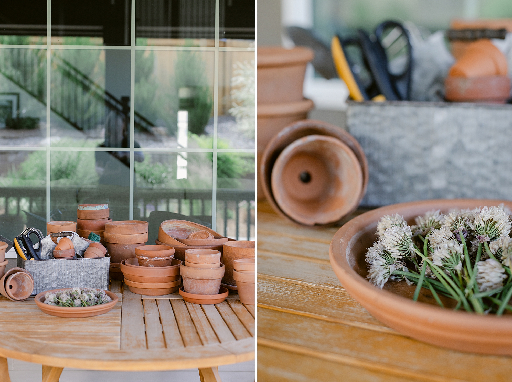 A wooden table holding various terracotta pots and gardening tools, with a decorative plate of flowers in the foreground.